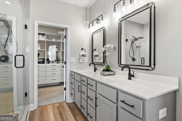 bathroom featuring a shower with door, wood-type flooring, and vanity