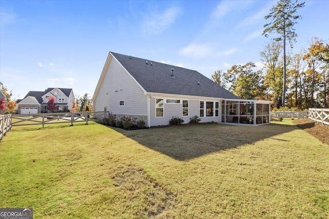 rear view of house featuring a lawn and a sunroom