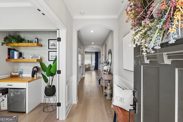 hallway featuring crown molding and light hardwood / wood-style flooring