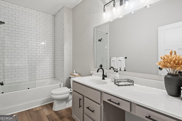 full bathroom with wood-type flooring, toilet, vanity, and tiled shower / bath