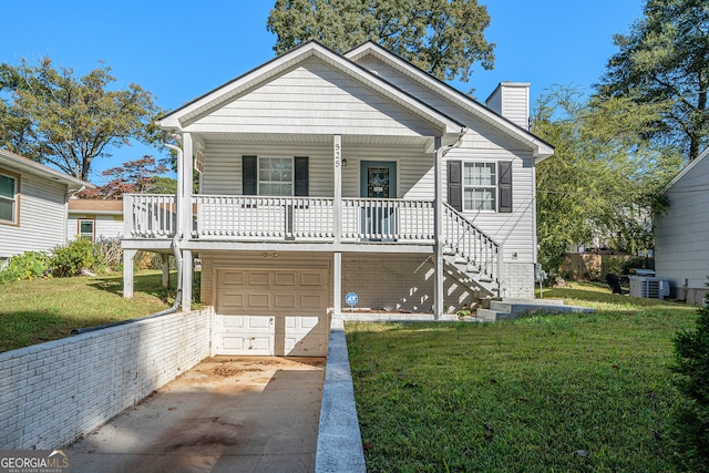 view of front of house featuring a front yard, a garage, cooling unit, and a porch