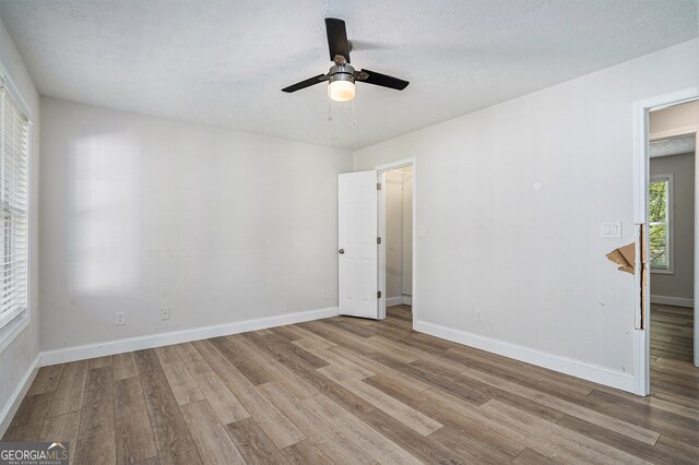 spare room featuring ceiling fan, a textured ceiling, and light wood-type flooring