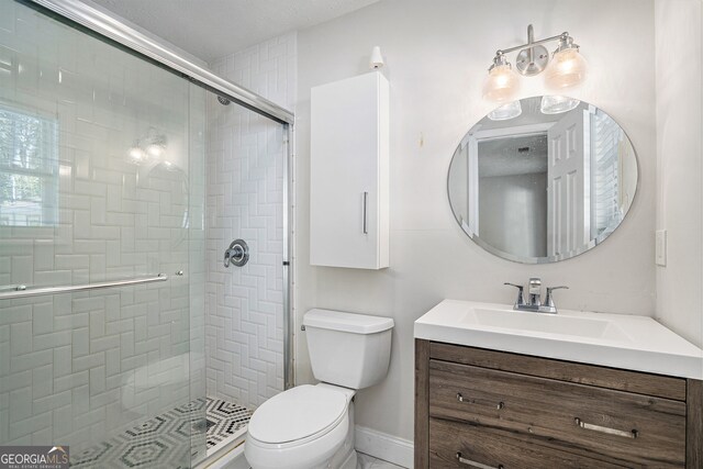 bathroom featuring vanity, toilet, and an enclosed shower