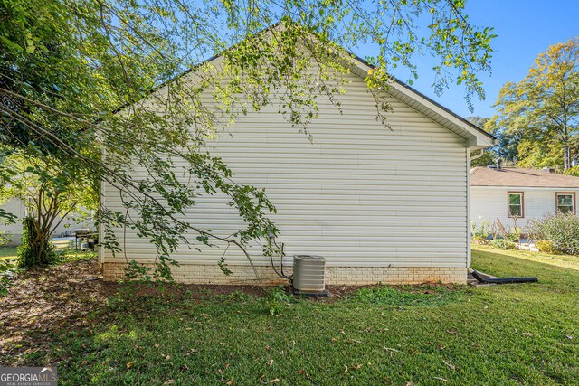 view of home's exterior featuring central AC and a lawn