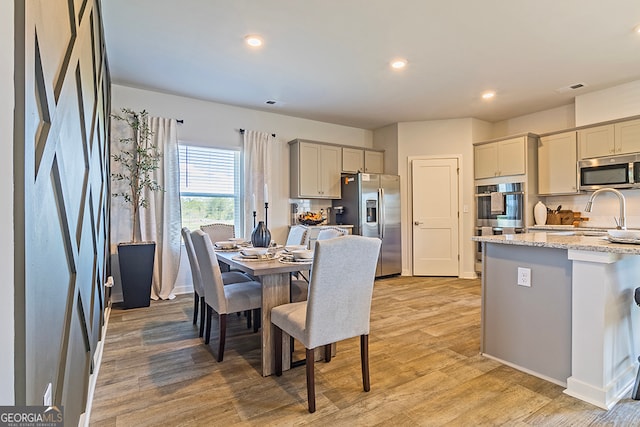 dining area with light hardwood / wood-style floors and sink