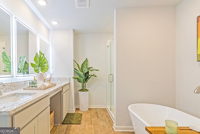 bathroom with vanity, hardwood / wood-style flooring, and separate shower and tub