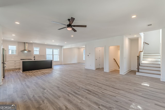 unfurnished living room featuring light hardwood / wood-style floors and ceiling fan