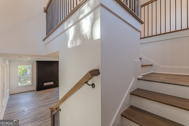 stairs featuring hardwood / wood-style flooring and a high ceiling