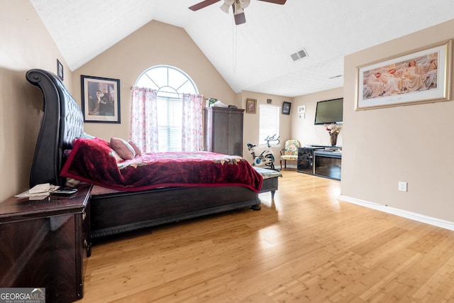 bedroom with ceiling fan, lofted ceiling, and light hardwood / wood-style flooring