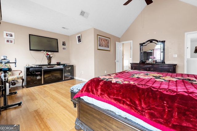 bedroom featuring wood-type flooring, ceiling fan, and high vaulted ceiling