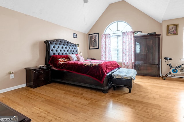 bedroom with light hardwood / wood-style flooring, ceiling fan, and vaulted ceiling