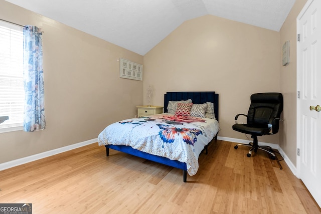 bedroom featuring hardwood / wood-style floors and vaulted ceiling