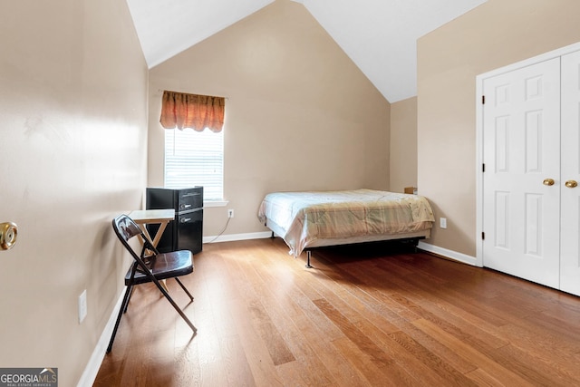 bedroom with wood-type flooring and lofted ceiling