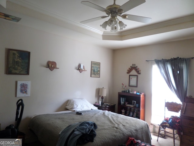 bedroom with ornamental molding, a raised ceiling, and ceiling fan