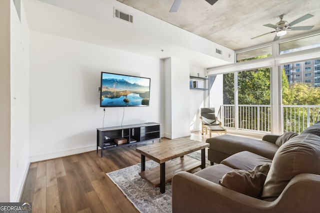 living room featuring dark wood-type flooring and ceiling fan