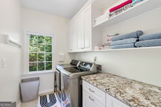 laundry area featuring washer and dryer and cabinets