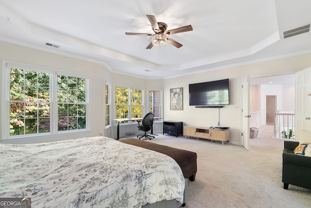 carpeted bedroom with ceiling fan, ornamental molding, and a tray ceiling