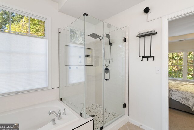 bathroom featuring separate shower and tub and a wealth of natural light