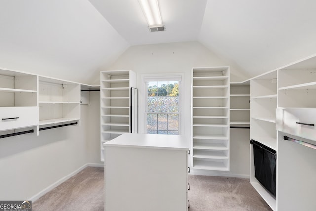 spacious closet with light carpet and vaulted ceiling