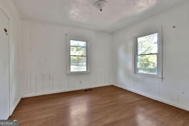 unfurnished room featuring a textured ceiling and dark hardwood / wood-style flooring