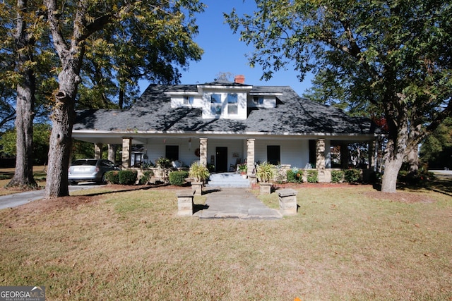 view of front of property featuring a front yard, a carport, and a porch