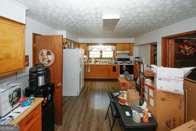 kitchen featuring white appliances, a textured ceiling, dark wood-type flooring, and sink