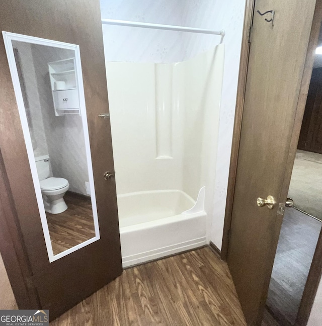 full bathroom featuring toilet, shower / bath combination, and wood finished floors