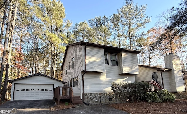 view of front of property with a detached garage and an outbuilding