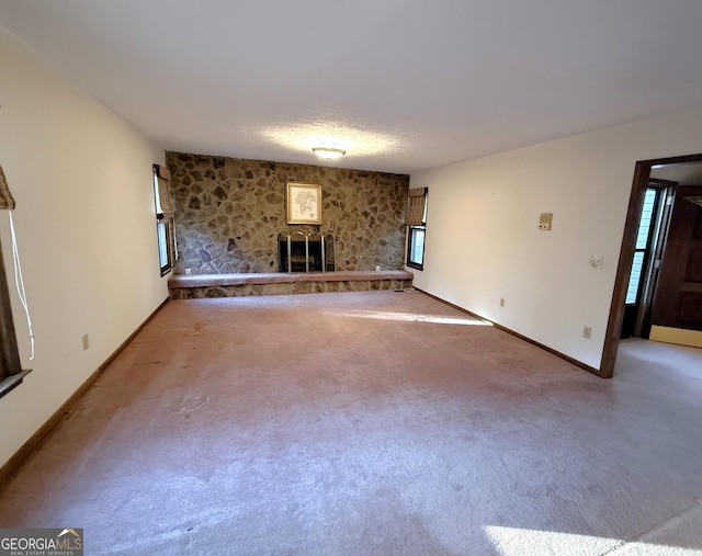 unfurnished living room featuring carpet flooring and baseboards