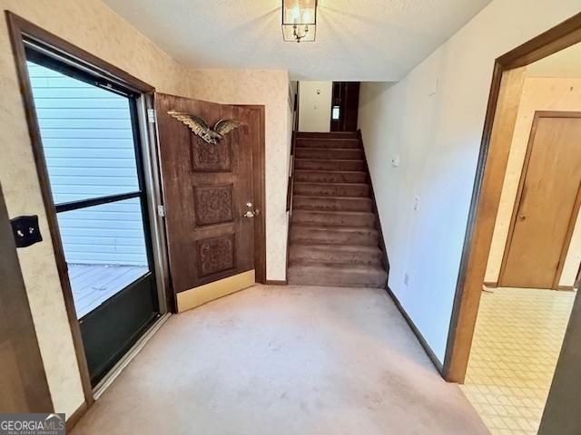 entrance foyer with stairs and baseboards