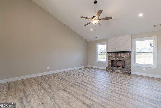 unfurnished living room with ceiling fan, high vaulted ceiling, light hardwood / wood-style flooring, and a fireplace