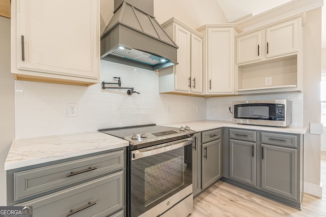 kitchen featuring light hardwood / wood-style flooring, custom range hood, stainless steel appliances, gray cabinets, and tasteful backsplash