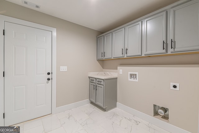 clothes washing area with cabinets, hookup for an electric dryer, and hookup for a washing machine