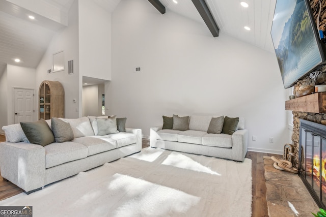 living room featuring a fireplace, beamed ceiling, high vaulted ceiling, and wood-type flooring