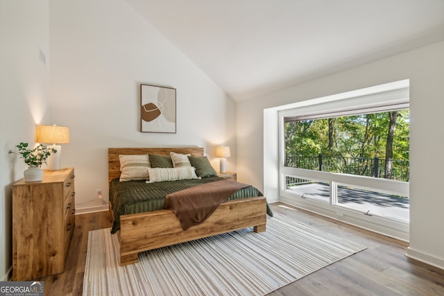 bedroom featuring light hardwood / wood-style floors and high vaulted ceiling