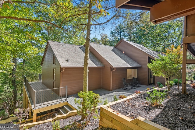 back of house featuring a wooden deck and a patio area