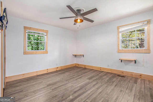 unfurnished room featuring wood-type flooring, a wealth of natural light, and ceiling fan