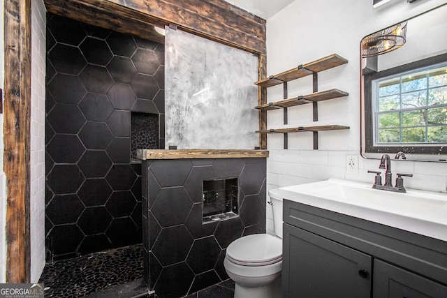 bathroom featuring vanity, toilet, and tile walls