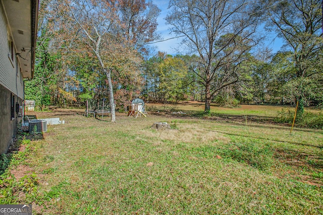 view of yard featuring a trampoline and central AC