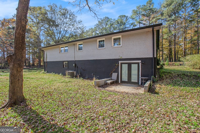 rear view of house featuring french doors, a yard, and central AC