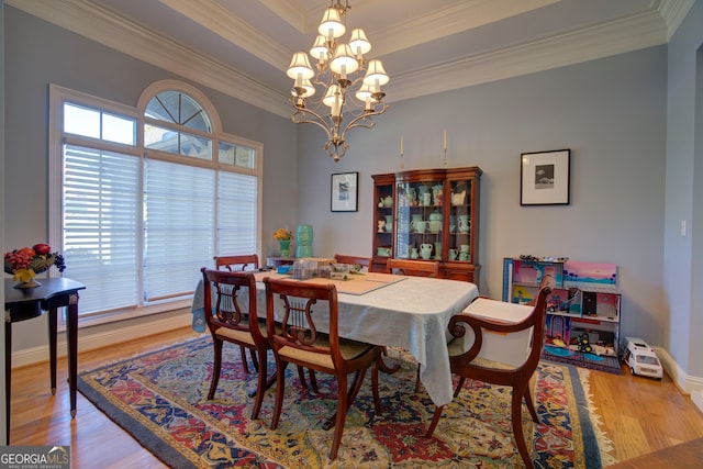 dining area with ornamental molding, a chandelier, and light wood-type flooring