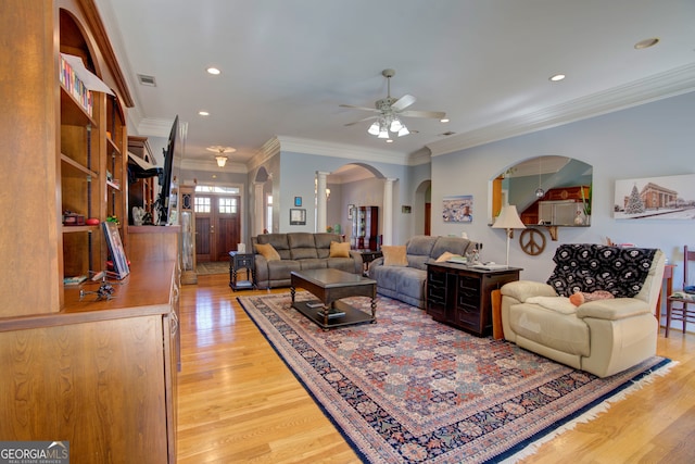 living room featuring crown molding, light hardwood / wood-style floors, and ceiling fan