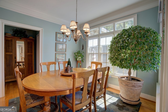 dining room featuring ornamental molding, wood-type flooring, and an inviting chandelier