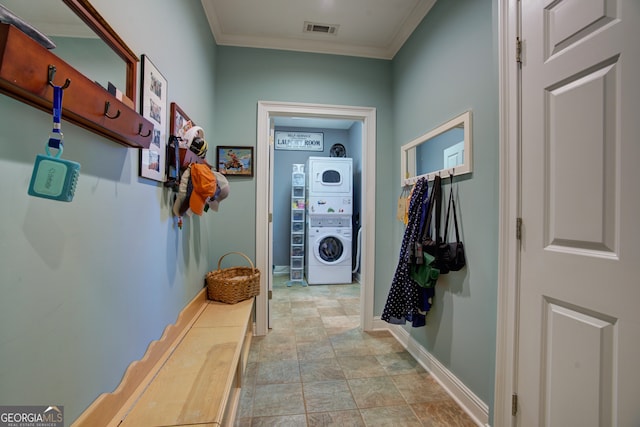 mudroom featuring stacked washer / drying machine and crown molding