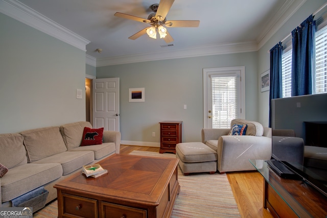 living room with light hardwood / wood-style flooring, ceiling fan, and crown molding