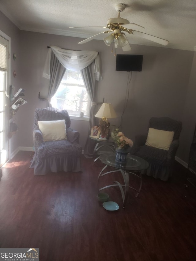 living area with ceiling fan, a textured ceiling, and dark hardwood / wood-style flooring