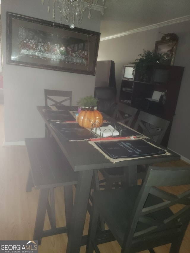 dining area with crown molding and hardwood / wood-style floors