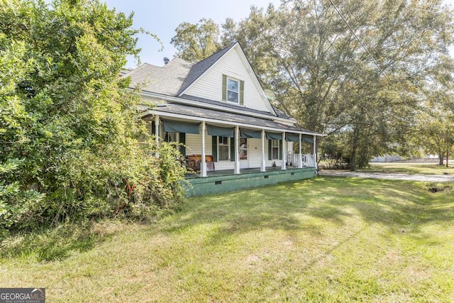 farmhouse featuring a porch and a front lawn