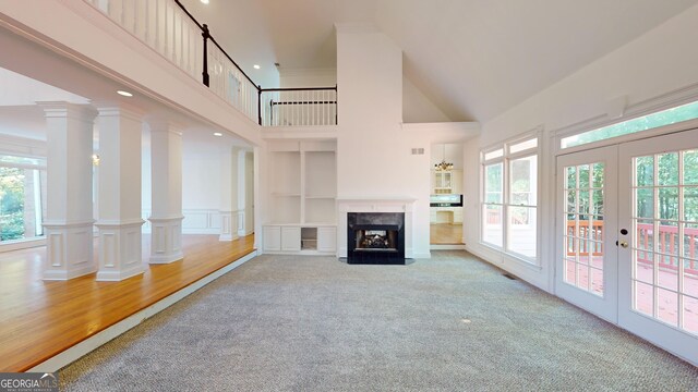 15 Greenridge Way, Newnan, GA 30265 - unfurnished living room with a towering ceiling, ornate columns, a high end fireplace, french doors, and carpet