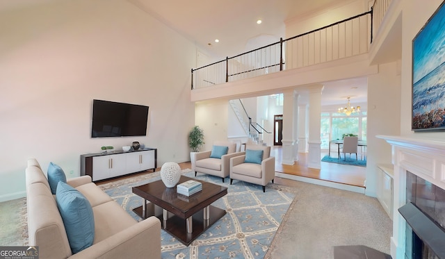 15 Greenridge Way, Newnan, GA 30265 - living room with an inviting chandelier, a fireplace, decorative columns, a towering ceiling, and stairway